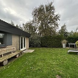 Geniet van de serene tuin bij Vakantiehuis A 209 in De Cocksdorp, Texel. Ontspannen op het terras te midden van de natuur op de Waddeneilanden.