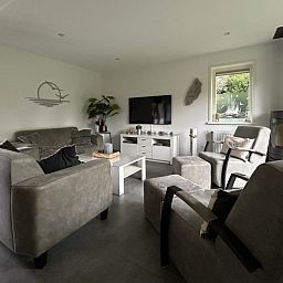 Stijlvolle woonkamer van Vakantiehuis A 209 in De Cocksdorp, Texel met comfortabele zithoek en moderne inrichting voor een ontspannen verblijf.