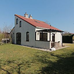 Vakantiehuis D 437 in De Cocksdorp, Texel, biedt een charmant terras met uitzicht op de groene omgeving van de Waddeneilanden.