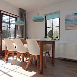 Lichte eetkamer in Vakantiehuis D 437, De Cocksdorp, Texel, met uitzicht op terras en moderne inrichting voor een ontspannen verblijf op de Waddeneilanden.