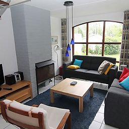 Cozy living room of Holiday home D 745 in De Cocksdorp, Texel with spacious seating area and views of the green surroundings.