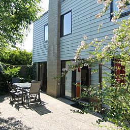 Geniet van de zonnige tuin bij Vakantiehuis A 383 in De Cocksdorp, Texel. Ontspannen op het terras te midden van de groene natuur.