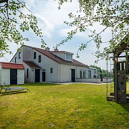Vakantiehuis D 473 in De Cocksdorp, Texel met ruime tuin en speeltoestel, ideaal voor gezinnen die genieten van de natuur op de Waddeneilanden.