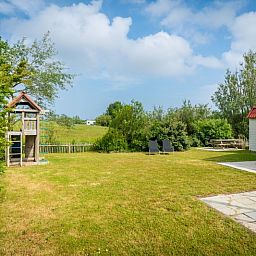 Ruime tuin van Vakantiehuis D 473 in De Cocksdorp, Texel. Geniet van het groene uitzicht en ontspannen sfeer op de Waddeneilanden.