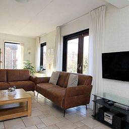 Gezellige woonkamer van Vakantiehuis B 261 in De Cocksdorp, Texel. Comfortabele zithoek met veel lichtinval en uitzicht op de tuin.