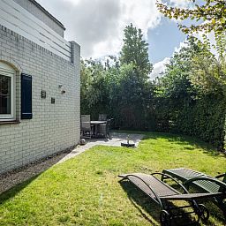Enjoy the serene garden of Holiday home F 549 in De Cocksdorp, Texel. Relax on the terrace of this charming vacation home on the Wadden Islands.