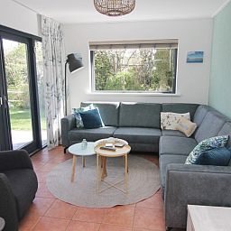 Gezellige woonkamer van Vakantiehuis A 143 in De Cocksdorp, Texel. Comfortabele zitruimte met uitzicht op de groene omgeving.