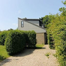 Vakantiehuis C 321 in De Cocksdorp, Texel omringd door groene natuur en een uitnodigend pad naar de ingang van deze comfortabele vakantiewoning.