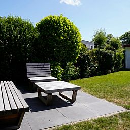Ontspan op het zonnige terras van Vakantiehuis D 770 in De Cocksdorp, Texel, omgeven door weelderige natuur en rustgevende tuinen.