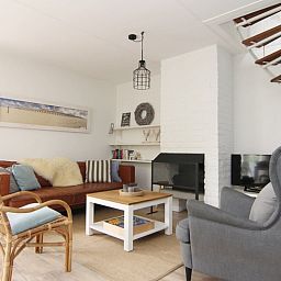 Gezellige woonkamer van Vakantiehuis D 610 in De Cocksdorp, Texel. Comfortabele zithoek met open haard voor een ontspannen verblijf.
