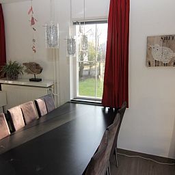 Gezellige eetkamer in Vakantiehuis D 720, De Cocksdorp, Texel met uitzicht op de tuin en stijlvolle inrichting.