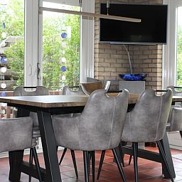 Gezellige eetkamer in Vakantiehuis A 267, De Cocksdorp, Texel. Comfortabele stoelen en veel lichtinval voor een ontspannen verblijf.