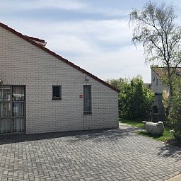 Das Ferienhaus D 439 in De Cocksdorp, Texel, bietet einen ruhigen Aussenbereich mit Terrasse und natuerlicher Umgebung auf den Watteninseln.