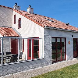 Das Ferienhaus D 489 in De Cocksdorp, Texel, bietet eine sonnige Veranda und einen grosszuegigen Aussenbereich fuer einen entspannten Aufenthalt auf den Watteninseln.