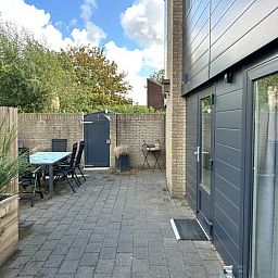 Geniet van het terras bij Vakantiehuis A 227 in De Cocksdorp, Texel, omringd door groene natuur op de Waddeneilanden.