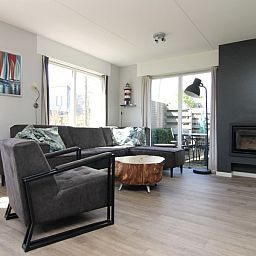 Cozy living room in Holiday Home B 011, De Cocksdorp, Texel, with modern furnishings and views of the Wadden Island garden.