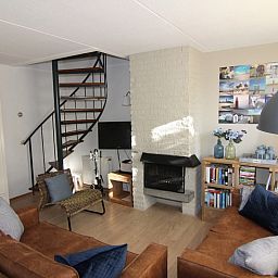 Gezellige woonkamer van Vakantiehuis D 696 in De Cocksdorp, Texel met comfortabele zithoek en sfeervolle open haard.