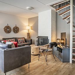 Gezellige woonkamer van Vakantiehuis D 694 in De Cocksdorp, Texel. Comfortabele zithoek met open haard in een sfeervol vakantiehuis.