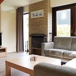 Gezellige woonkamer van Vakantiehuis B 031 in De Cocksdorp, Texel met comfortabele zithoek en grote ramen.