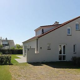 Vakantiehuis D 706 in De Cocksdorp, Texel biedt een zonnige buitenruimte met een charmante tuin en moderne architectuur.