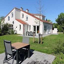 Vakantiehuis D 706 in De Cocksdorp, Texel biedt een zonnig terras met tuinzicht, ideaal voor een ontspannen verblijf op de Waddeneilanden.