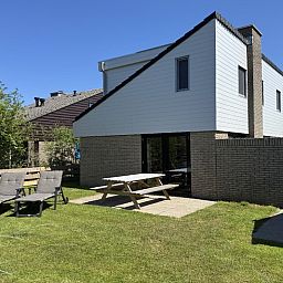 Enjoy the sunny terrace of Holiday home A 301 in De Cocksdorp, Texel, Wadden Islands, surrounded by green nature.