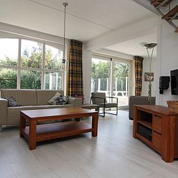 Gezellige woonkamer van Vakantiehuis G 769 in De Cocksdorp, Texel met ruime zithoek en uitzicht op de groene tuin.