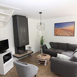 Gezellige woonkamer in Vakantiehuis D 800, De Cocksdorp, Texel met moderne inrichting en comfortabele zithoek voor een ontspannen verblijf.