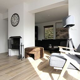Cozy living room in Holiday home A 075, De Cocksdorp, Texel with modern furnishings and lots of natural light.