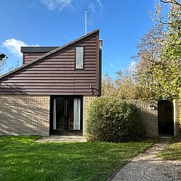 Vakantiehuis A 051 in De Cocksdorp, Texel, biedt een serene ontsnapping met een prachtig omgeven tuin en moderne architectuur.