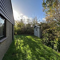 Rustige tuin bij Vakantiehuis A 051 in De Cocksdorp, Texel. Geniet van de groene omgeving en privacy van dit charmante vakantieverblijf.