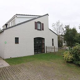 Vakantiehuis E 655 in De Cocksdorp, Texel biedt een charmante buitenaanzicht met groene omgeving en rustige sfeer op de Waddeneilanden.