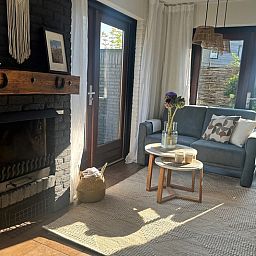 Gezellige woonkamer van Vakantiehuis C 077 in De Cocksdorp, Texel met comfortabele zithoek en sfeervolle open haard.