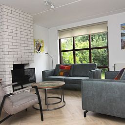 Gezellige woonkamer van Vakantiehuis D 475 in De Cocksdorp, Texel, met moderne meubels en uitzicht op de groene natuur van de Waddeneilanden.