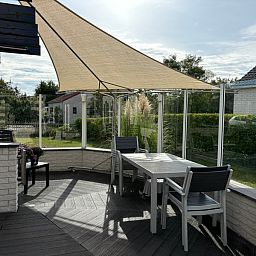 Geniet van de zonnige veranda bij Vakantiehuis F 471 in De Cocksdorp, Texel. Ontspan op het terras met uitzicht op de groene omgeving.