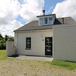 Vakantiehuis F 808 in De Cocksdorp, Texel, omgeven door groene natuur en een zonnige veranda, ideaal voor een ontspannen verblijf op de Waddeneilanden.