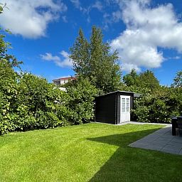 Geniet van de serene tuin van Vakantiehuis E 545 in De Cocksdorp, Texel. Ontspan in de groene omgeving van deze comfortabele vakantiewoning.