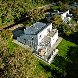 Gemuetliches Wohnzimmer des Ferienhauses F 682 in De Cocksdorp, Texel mit moderner Einrichtung und Blick auf die Natur des Wattenmeeres.