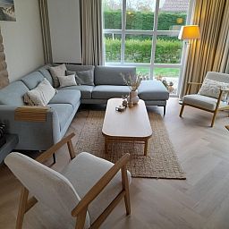 Cozy living room of Holiday home F 791 in De Cocksdorp, Texel, with comfortable seating area and views of green surroundings.