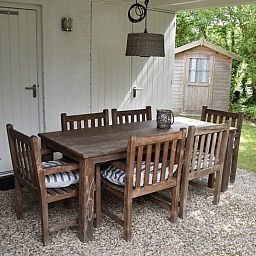 Geniet van de rust op de overdekte veranda van Vakantiehuis F 455 in De Cocksdorp, Texel, met uitzicht op de groene omgeving.