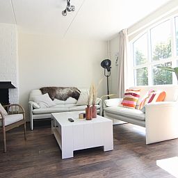 Gemuetliches Wohnzimmer des Ferienhauses F 567 in De Cocksdorp, Texel. Gemuetliche Sitzecke mit viel Tageslicht und moderner Einrichtung.