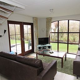 Gezellige woonkamer van Vakantiehuis E 571 in De Cocksdorp, Texel, met uitzicht op de tuin en comfortabele zithoek.