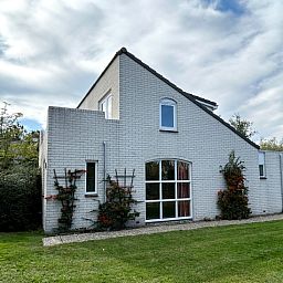 Vakantiehuis F 647 in De Cocksdorp, Texel, biedt een serene buitenkant met groene tuin en weelderige natuur, ideaal voor ontspanning op de Waddeneilanden.