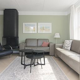 Stijlvolle woonkamer in Vakantiehuis F 691, De Cocksdorp, Texel met comfortabele banken en moderne inrichting, ideaal voor ontspanning.