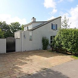 Vakantiehuis F 782 in De Cocksdorp, Texel, biedt een charmante buitenaanblik met een uitnodigende oprit en groene omgeving.