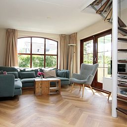 Gemuetliches Wohnzimmer im Ferienhaus F 789, De Cocksdorp, Texel mit geraeumiger Sitzecke und Gartenblick, ideal fuer einen entspannten Aufenthalt.