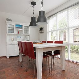 Gezellige eetkamer van Vakantiehuis E 646 in De Cocksdorp, Texel. Ruime binnenruimte met veel lichtinval en moderne inrichting.