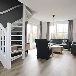 Lichte en ruime woonkamer van Vakantiehuis E 507 in De Cocksdorp, Texel. Gezellig interieur met uitzicht op de natuur van de Waddeneilanden.