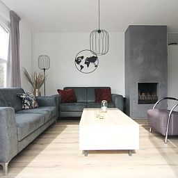 Gezellige woonkamer van Vakantiehuis E 507 in De Cocksdorp, Texel. Comfortabele zitruimte met moderne inrichting en sfeervolle open haard.