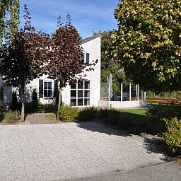 Das Ferienhaus F 778 in De Cocksdorp, Texel, bietet einen ruhigen Aussenbereich mit gruener Umgebung und einer grossen Terrasse zum Entspannen auf den Watteninseln.